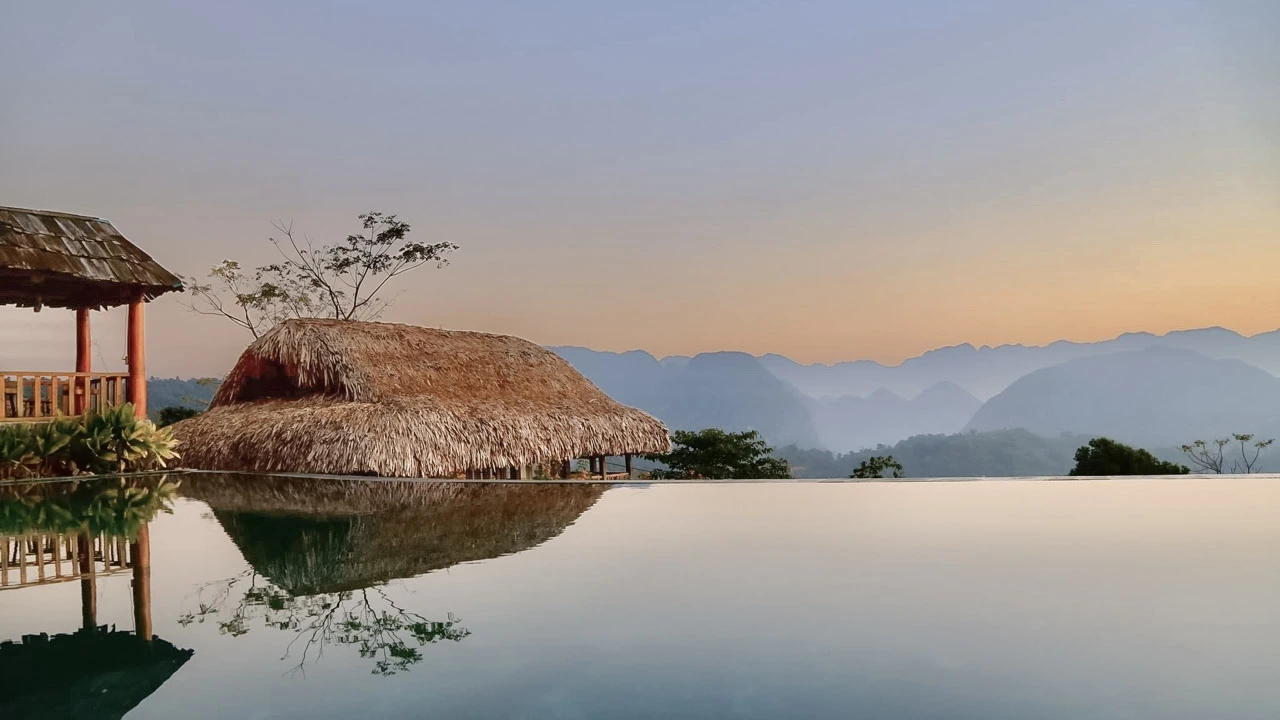 Late afternoon light falls across cultivated slopes and scattered houses in Pù Luông.